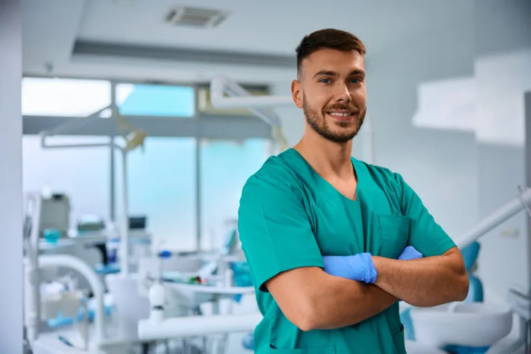 Dentista sorridente em consultório moderno.
